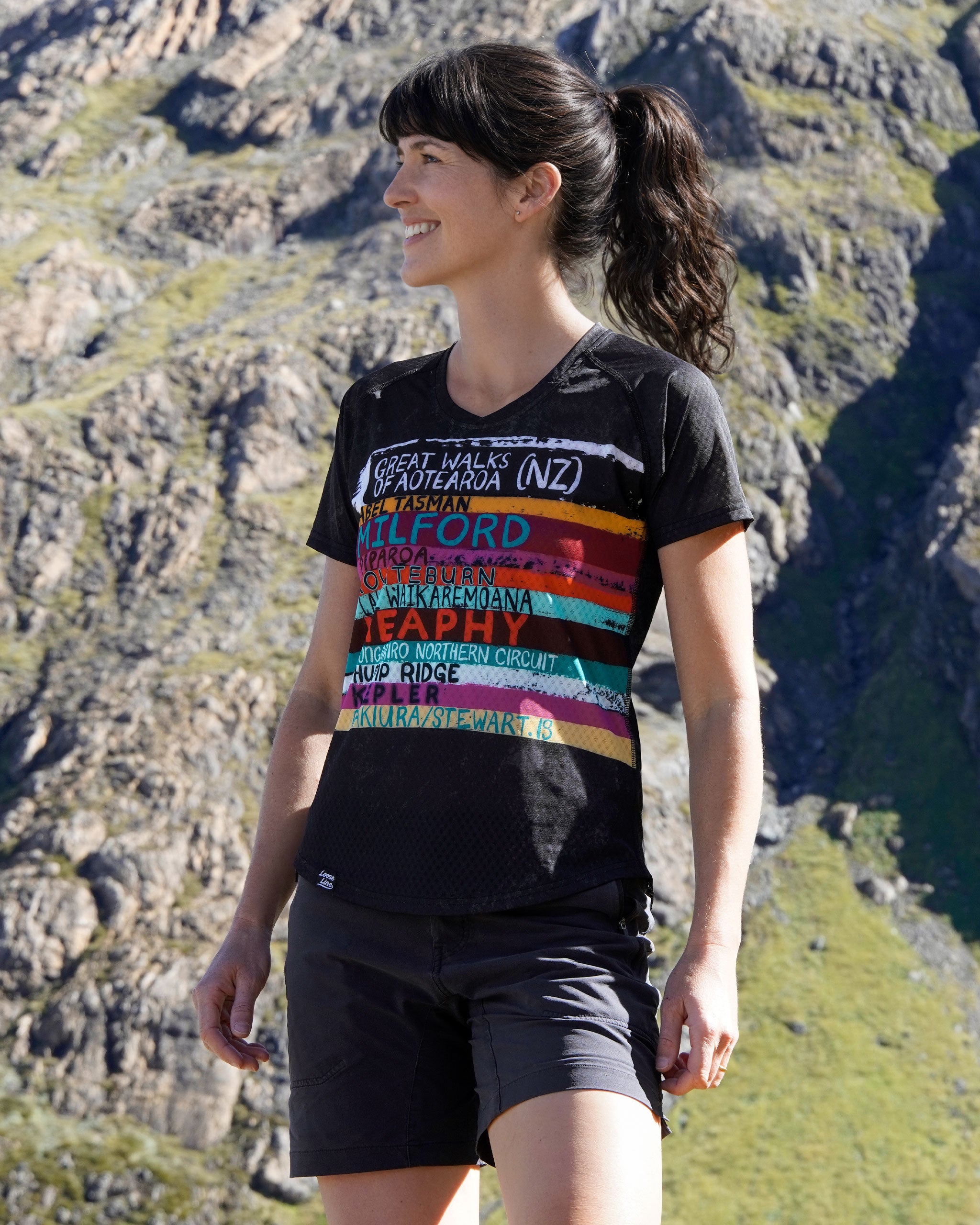 Fit woman wearing the great walks of aotearoa t-shirt in a mountainous landscape in NZ.