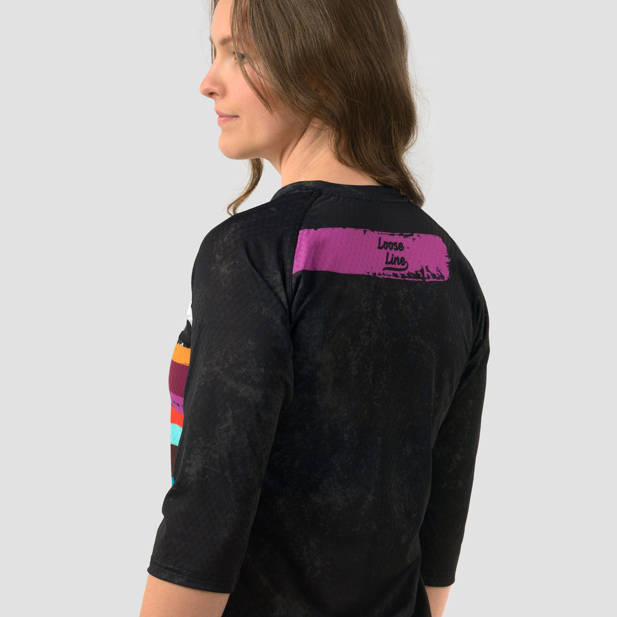 Woman's back view wearing a black 3/4 sleeve activewear featuring the great walks of New Zealand.