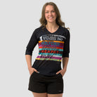 A fit woman wearing a black 3/4 sleeve activewear top featuring the great walks of New Zealand featuring colourful brushstrokes with each great walk listed.